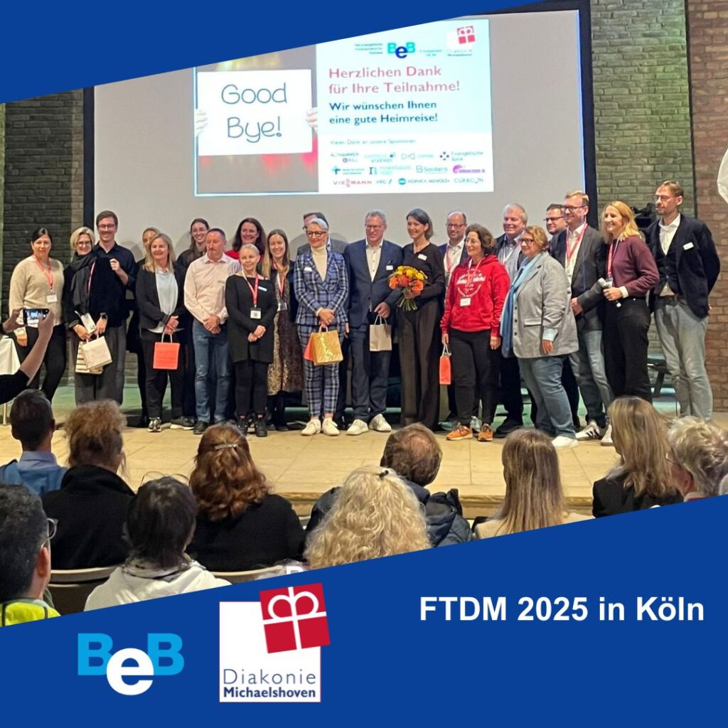 Gruppenbild vor Leinwand. Logos von BeB und Diakonie Michaelshoven. FTDM 2025 in Köln